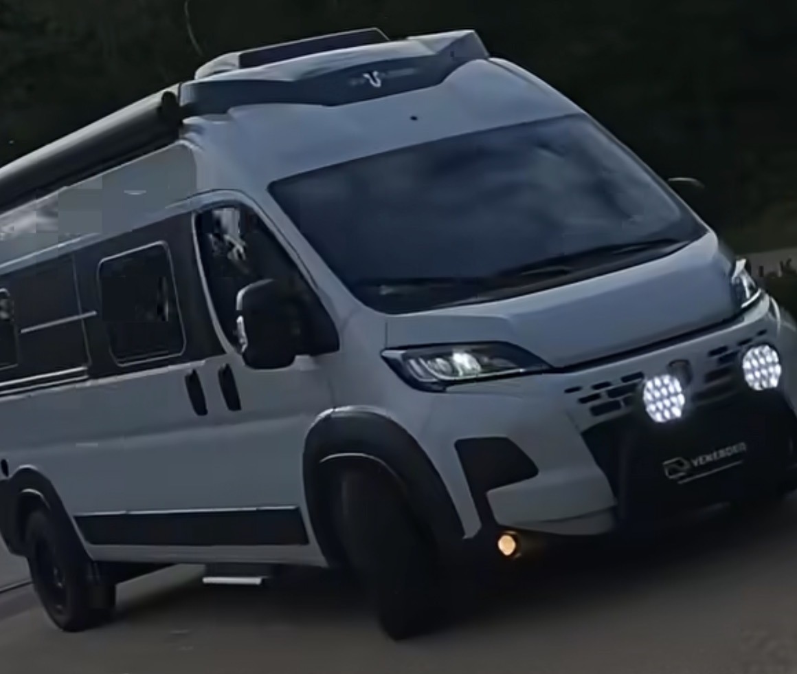 White Fiat Ducato high-top camper with front light bar, LED spot lights, extended wheel arches, awning and all-terrain tyres